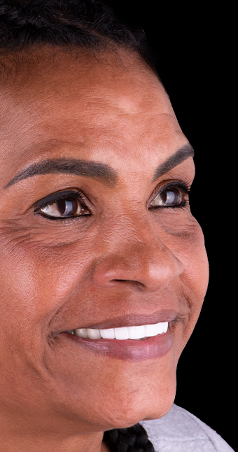 middle age patient from Prime Advanced Dentistry smiling with her dental implant bridges