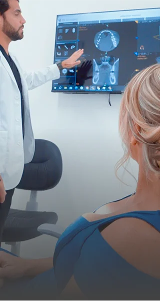 Prosthetist Gustavo Moreno with a patient explaining details about her dental procedure